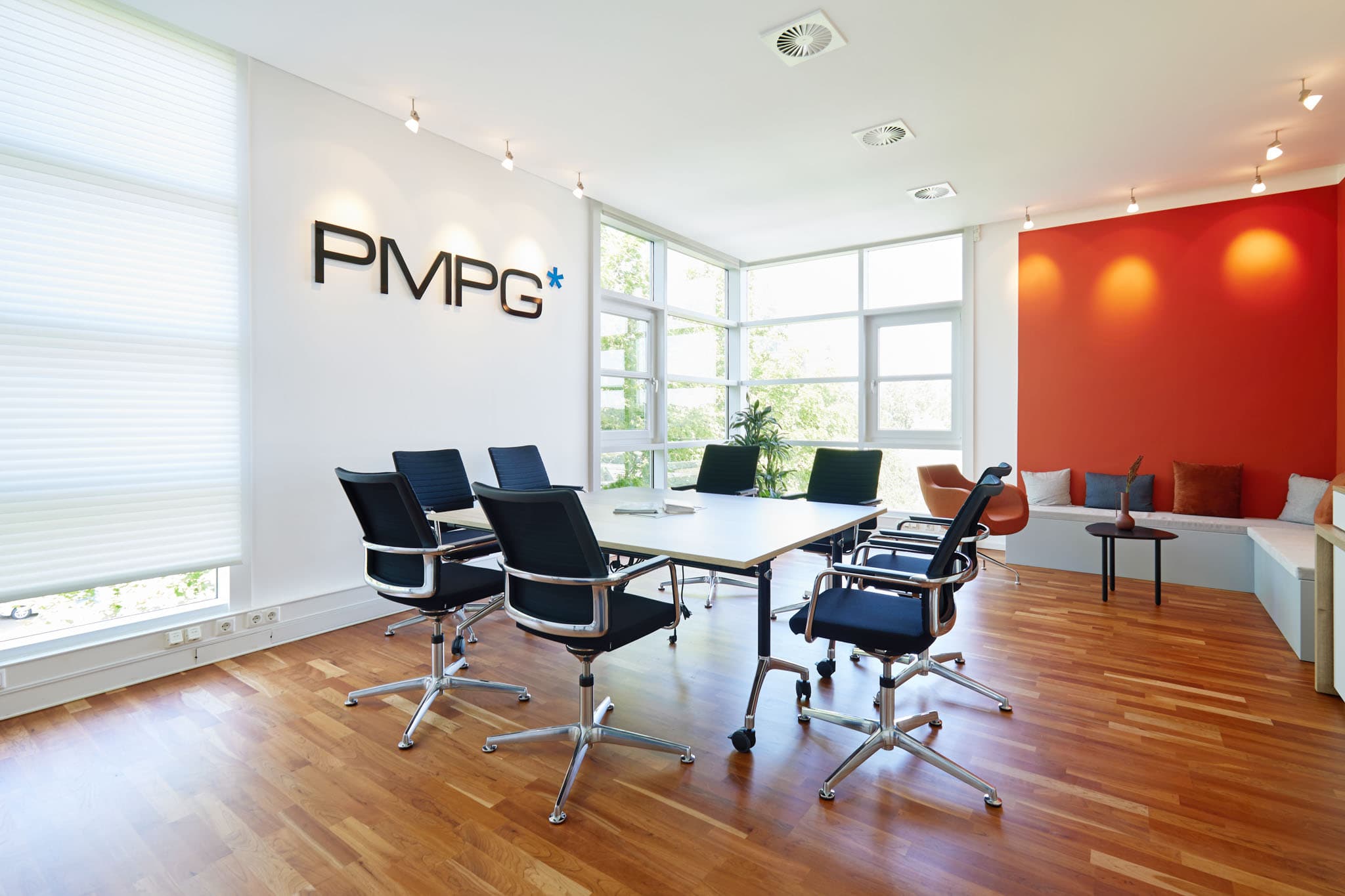 Besprechungsraum am PMPG-Standort Aachen mit PMPG-Logo an der Wand