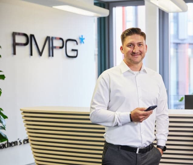 Maik Stang, Datenschutzbeauftragter (TÜV) und Datenschutzauditor (GDDcert. EU) bei PMPG, am Empfang vor dem PMPG-Logo